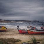 Botes en la playa de Punta del Diablo en la costa oceánica de Rocha