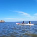 Dos mujeres navegan en un bote adaptado en el Río de la Plata. La que lleva los remos está sentada en un asiento adaptado