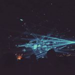Haces de luces azules sobre bolas de espejo en una discoteca repleta de gente bailando