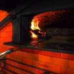 Imagen del fuego dentro de un horno a leña de ladrillos rojos