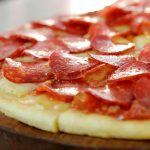 Pizzeta redonda con muzzarella, cubierta con pepperoni